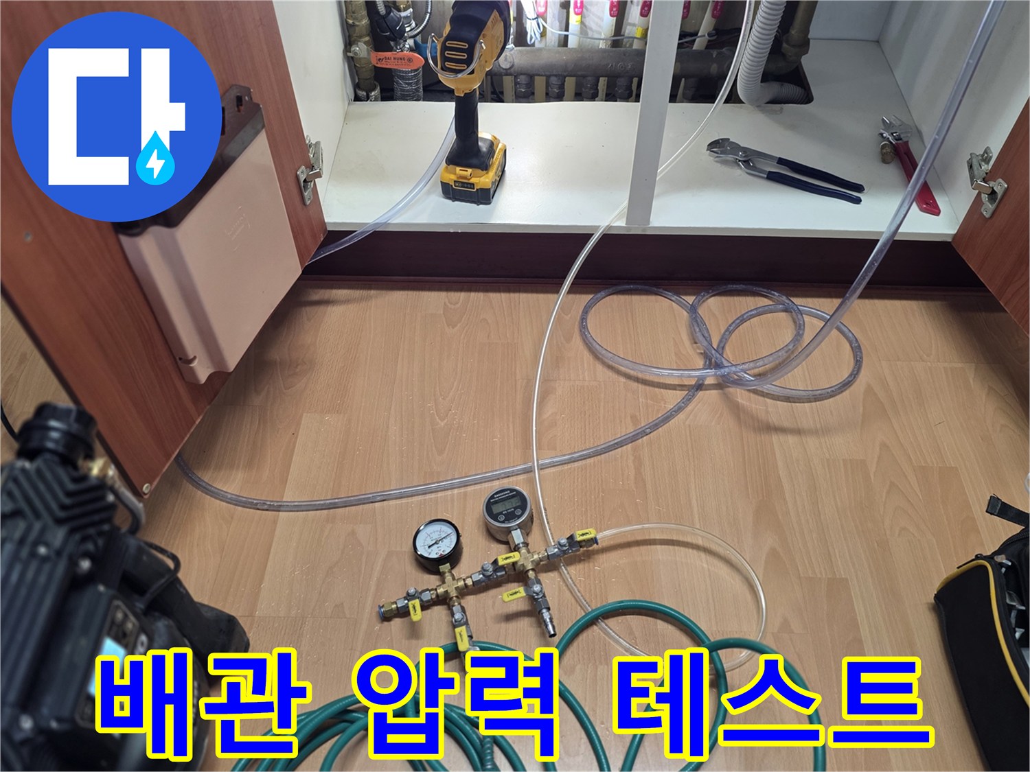 싱크대 하부장에서 진행하는 배관 공압 테스트 장면