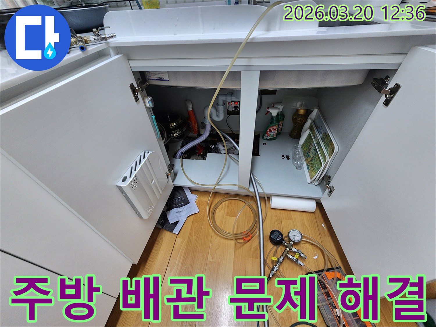 싱크대 하부의-배관에서-발생한-누수 문제를-해결하기 위해-전문 장비를-사용하는-모습입니다.