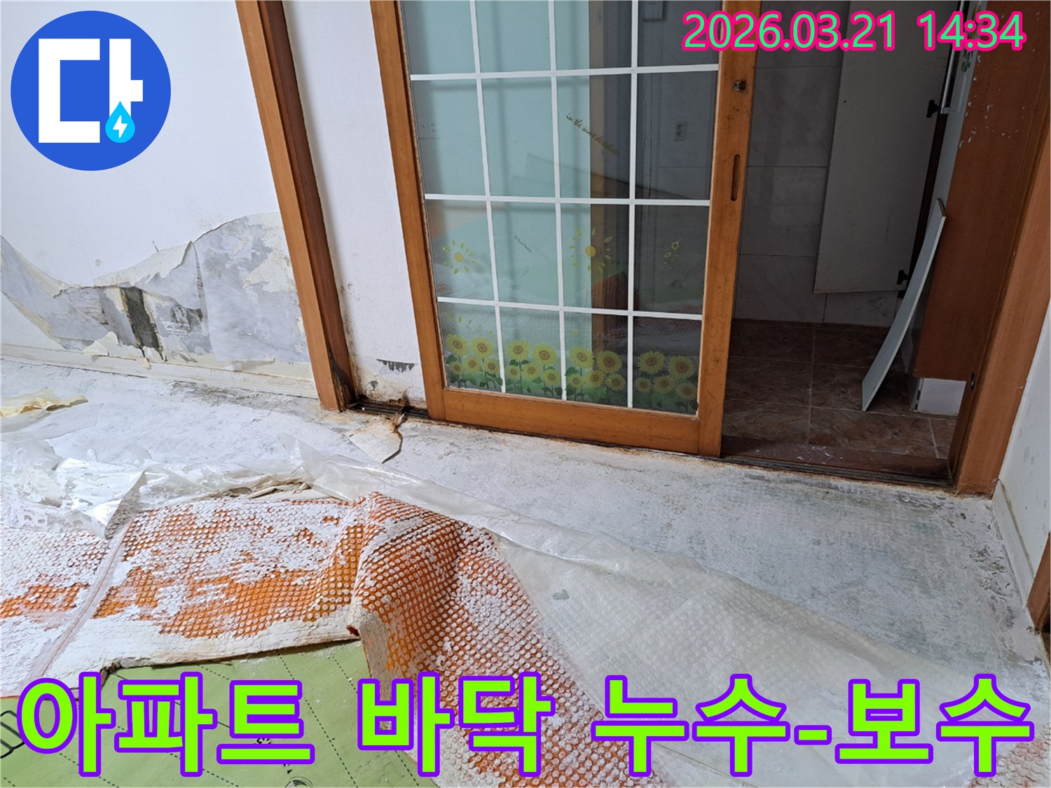 아파트 내부에서 발생한 누수로-벽면과 바닥에 습기가 차고-손상이 진행되어-전문가가 방수 및 보수 작업을 준비하는 모습입니다.