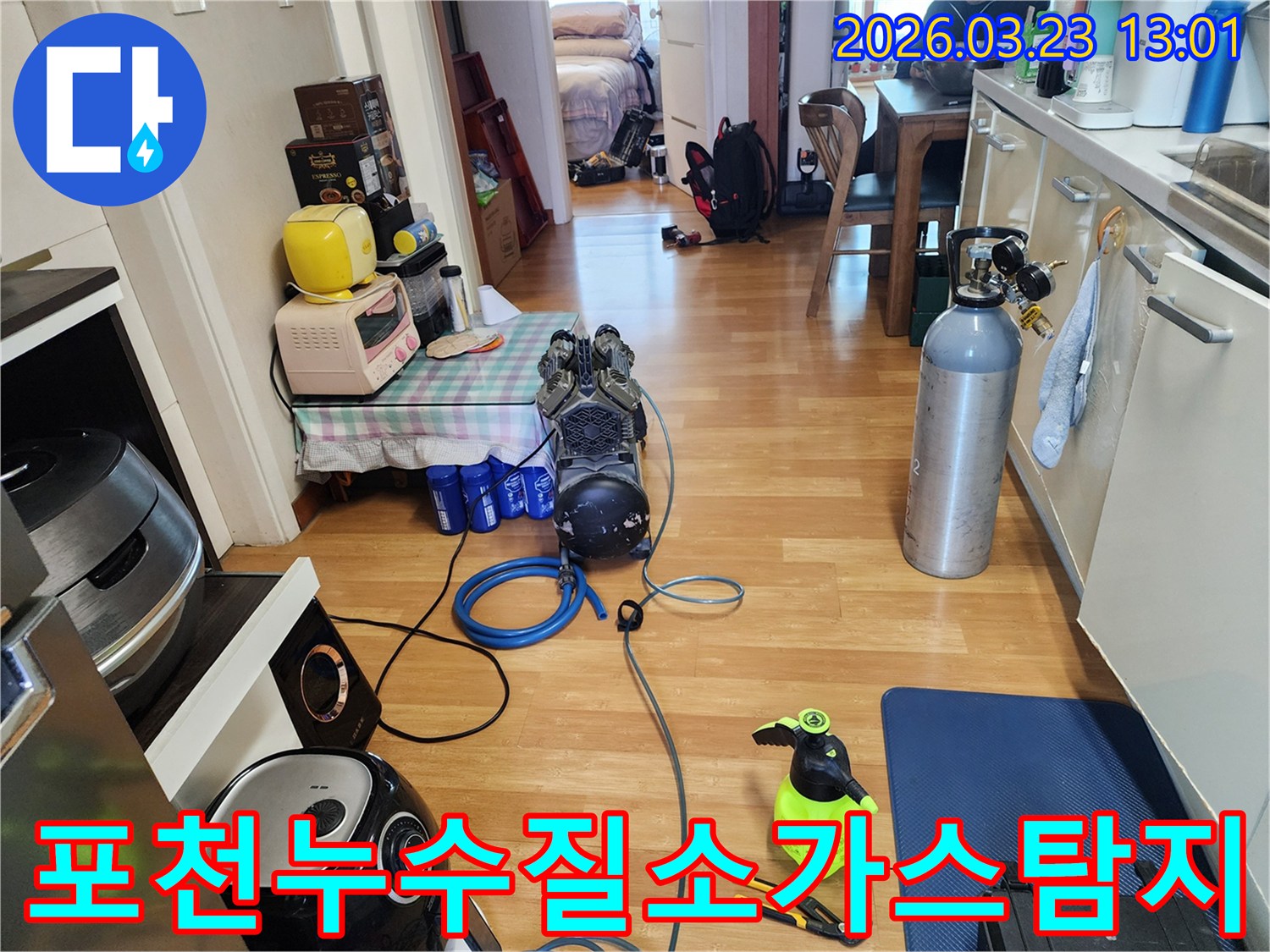 주택 내부에서 누수 원인을 찾기 위해-질소 가스 실린더와 탐지 장비를 연결하고-정밀 진단을 준비하는 모습