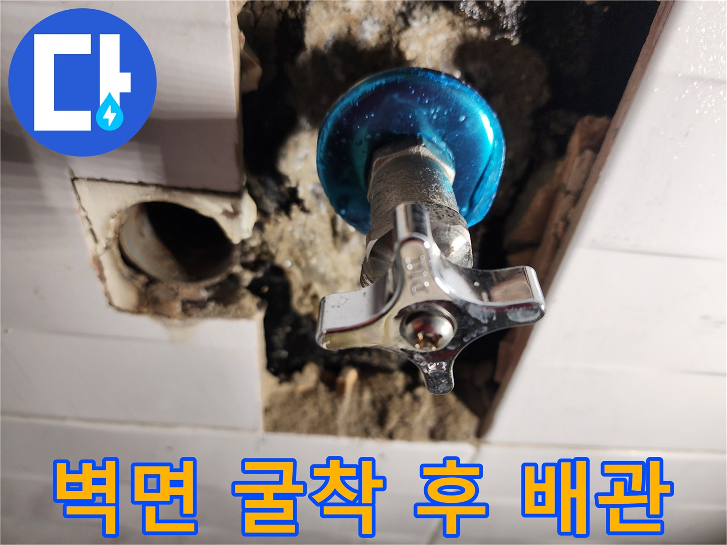 타일 제거 후 노출된 파란색 손잡이의 직수 밸브와 배관