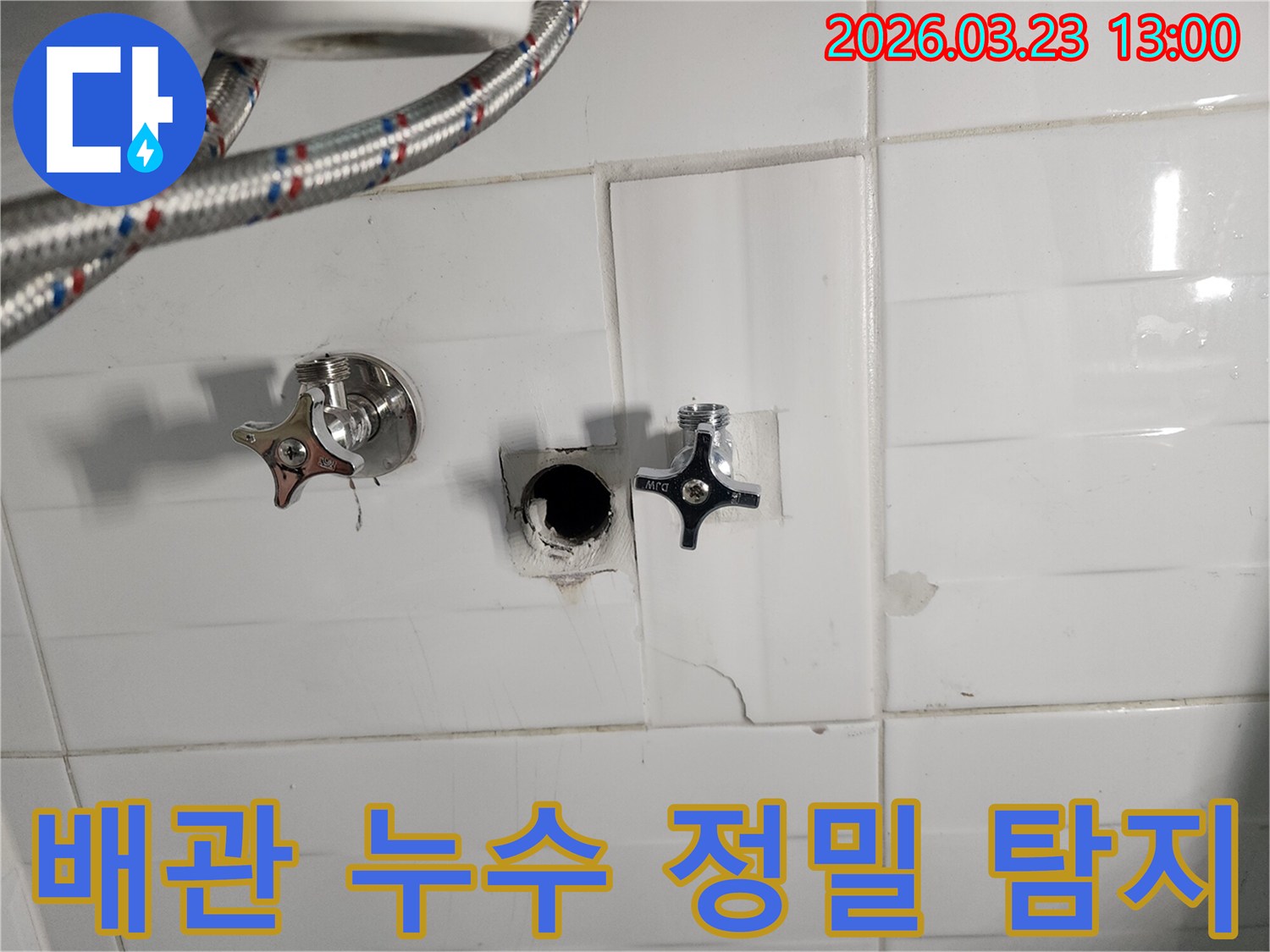 하얀색 타일 벽면의-수도 배관 연결 부위에서-누수가 확인되어-타일을 제거하고-배관을 점검하는-배관 누수 현장입니다.