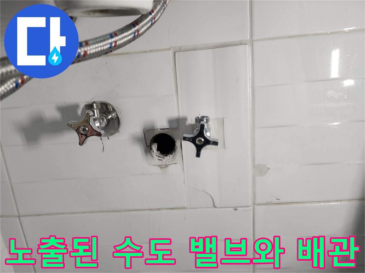 화장실 벽면을 파내어 드러낸 수도 부속과 연결 호스의 모습입니다.