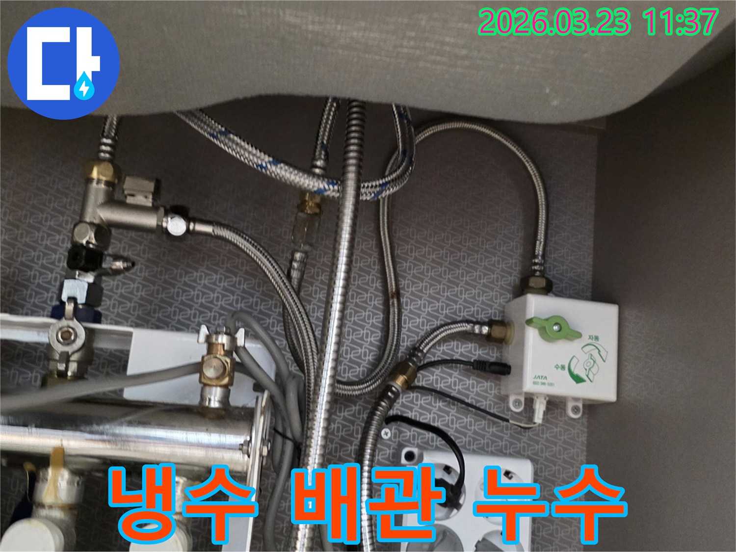 싱크대 하부장 내부의 냉수-배관과 정수기-밸브-수도-호스-전기 콘센트가-보이는 곳에서-누수 흔적을-찾아내고 있습니다.