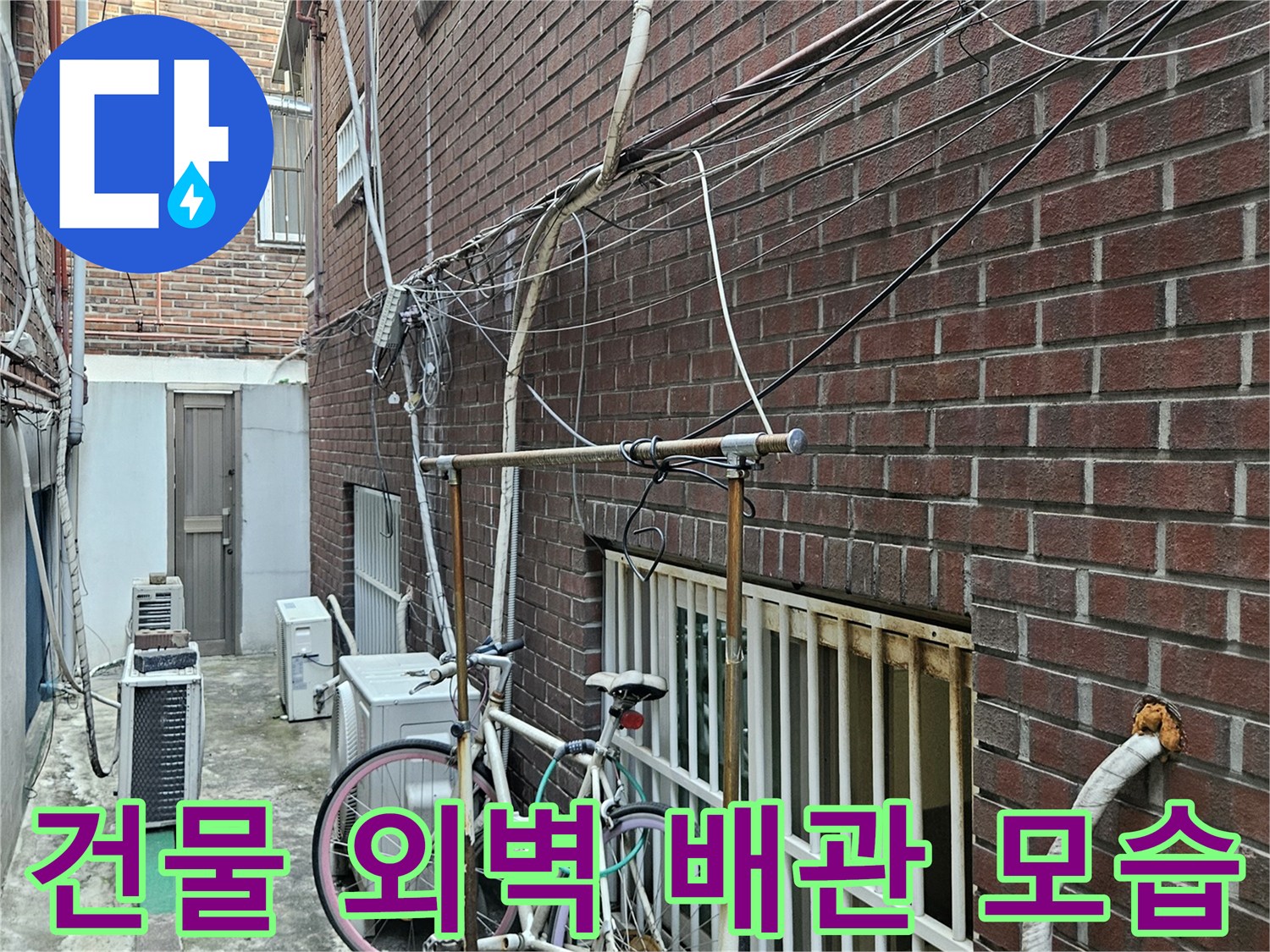 붉은색 벽돌 건물-외부로 노출된 배관과 전선들