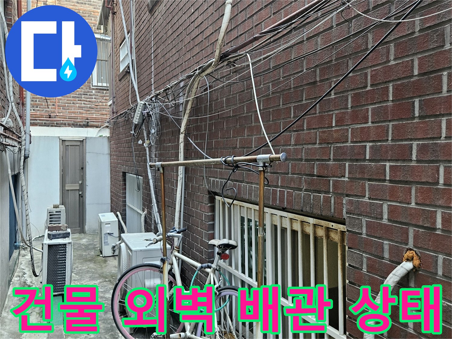 중랑구 건물 외벽의 붉은 벽돌 구조와 노출된 배관 모습입니다.