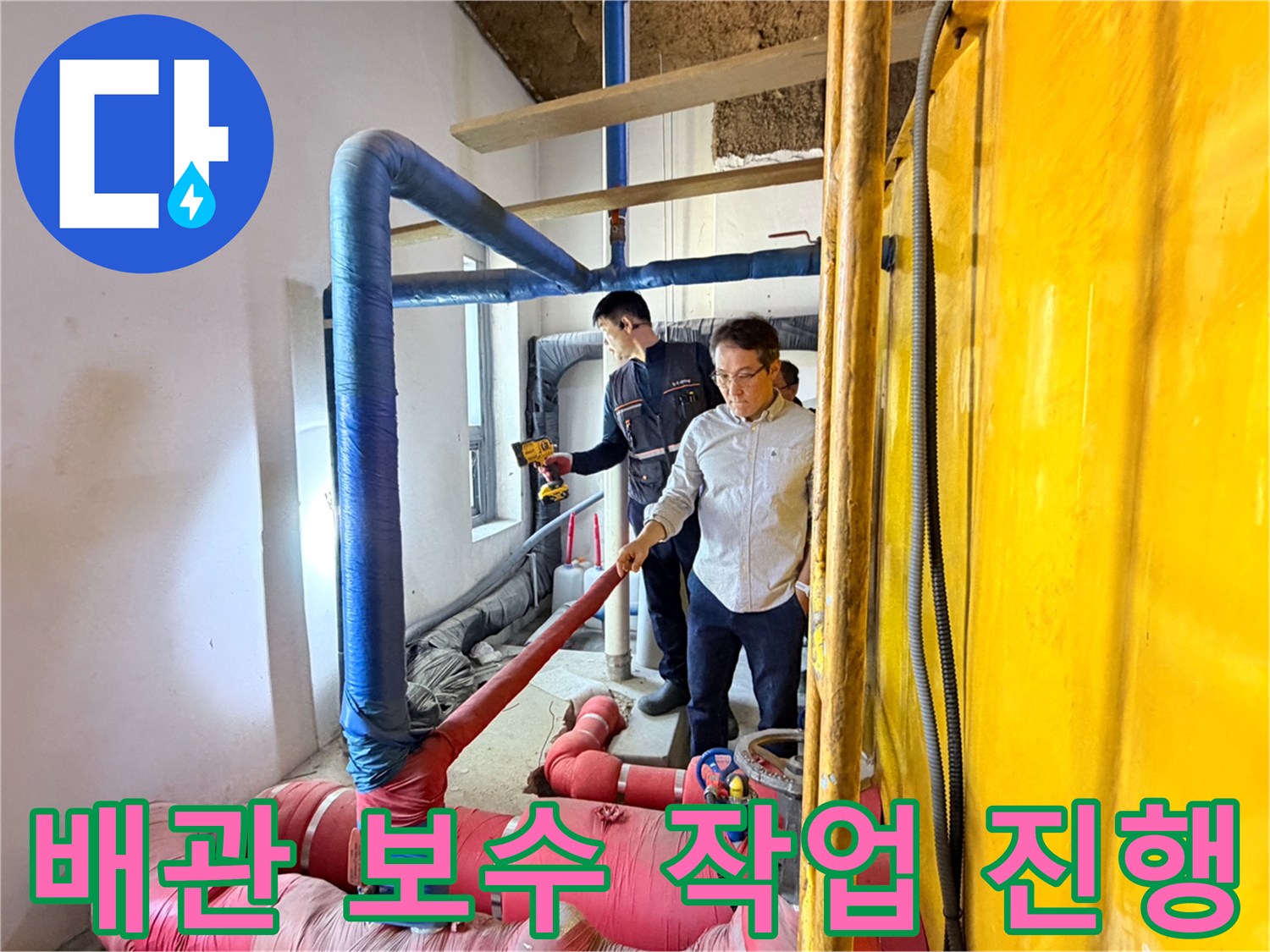 작업자가 분홍색과 파란색 배관이 얽힌 복잡한 구조물 사이에서 보수를 준비하고 있습니다.