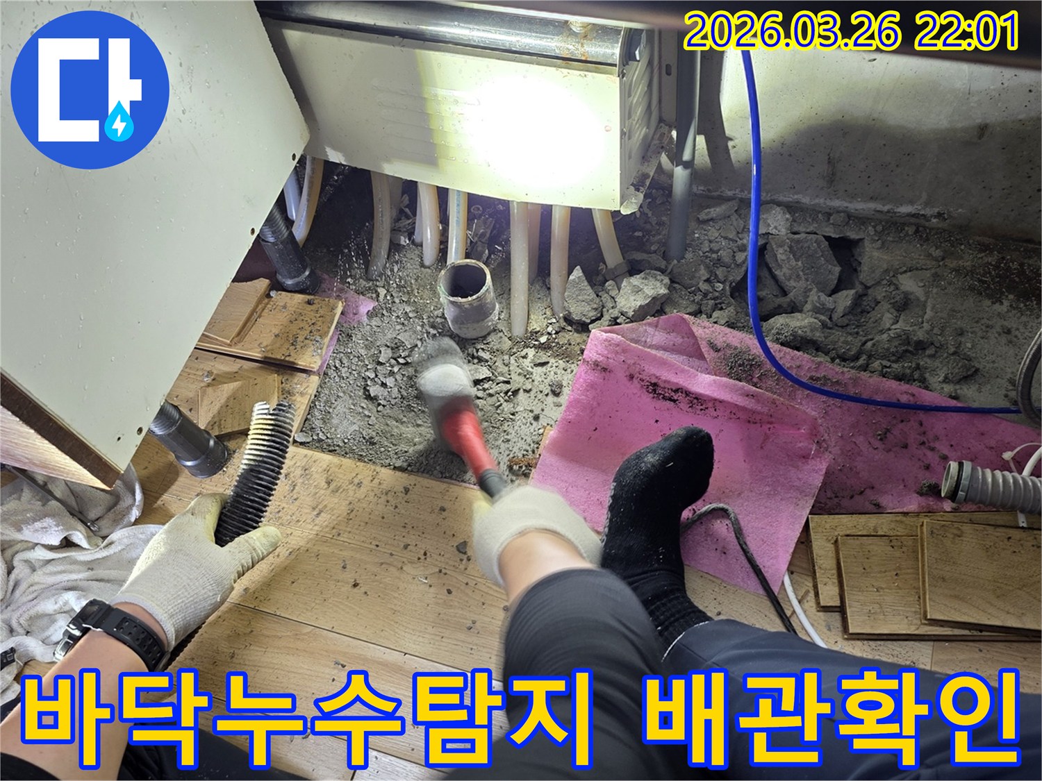 누수 탐지를 위해 바닥을 조심스럽게 파쇄하고 배관 상태를 확인하는 작업 현장