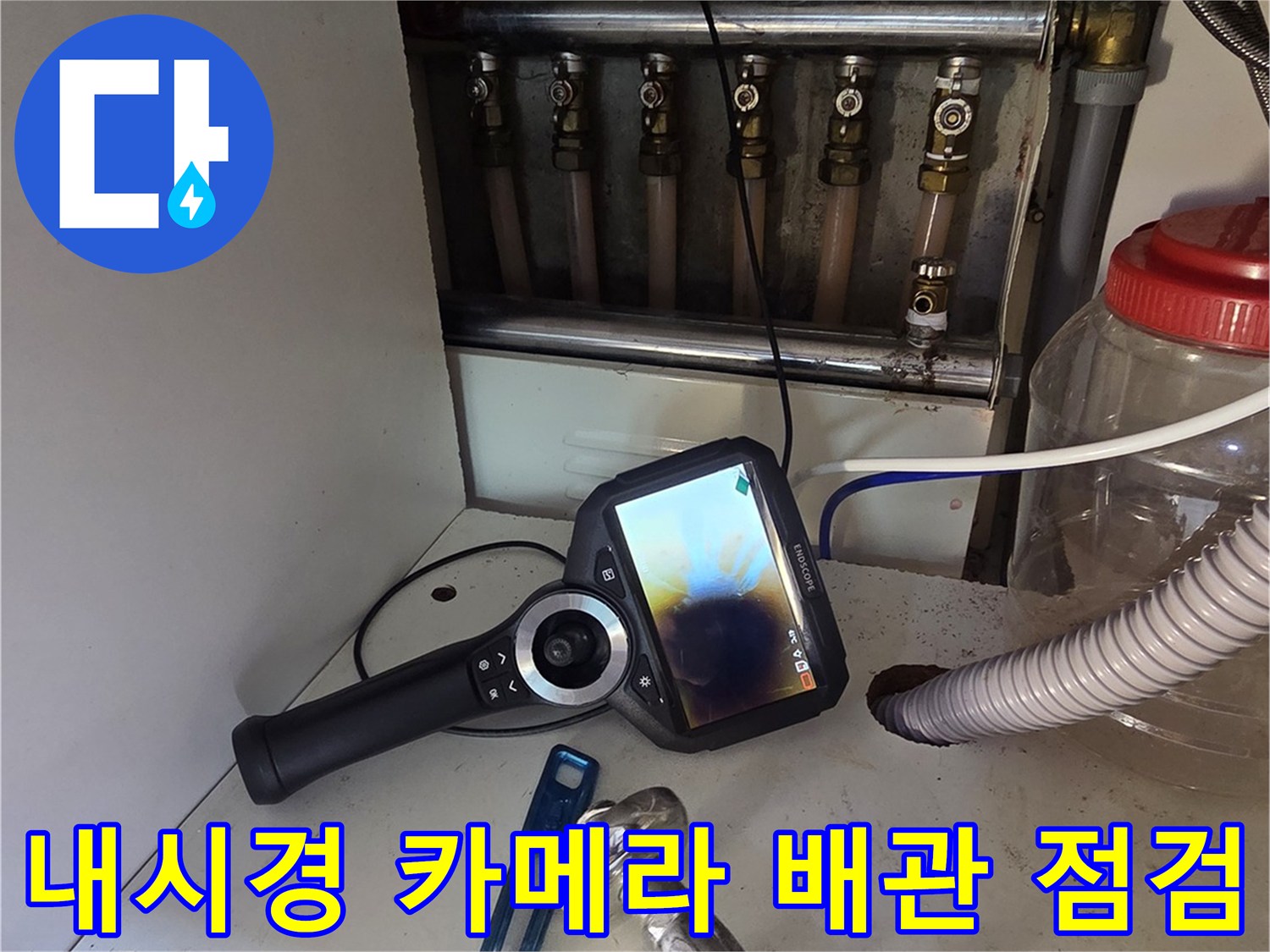 싱크대 하부 배관의 이상 유무를 파악하기 위해 내시경 카메라를 사용하는 모습