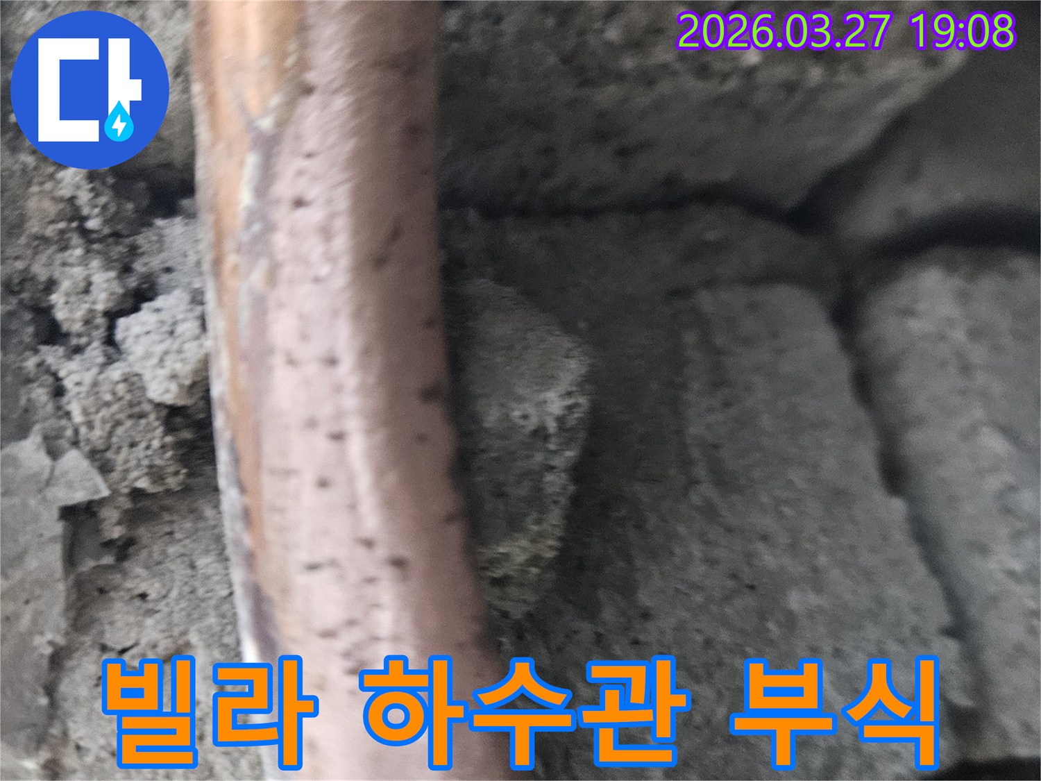 콘크리트-구조물-사이에-놓인-오래된-빌라-하수-배관의-심한-부식과-누수-현상을-보여주는-사진입니다