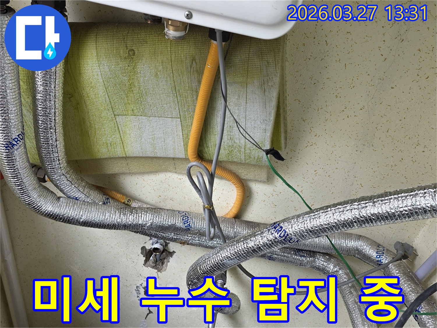 보일러-하단부의-배관과-전선이-복잡하게-얽혀있는-모습을-보여주며-육안으로-확인하기-어려운-미세-누수-탐지를-위한-준비-단계입니다.