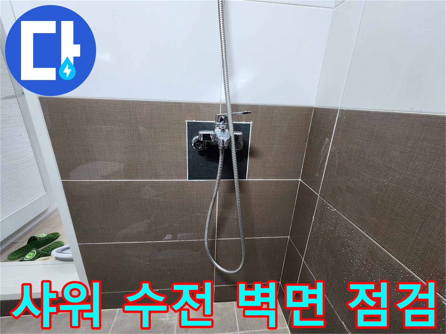 벽면에 고정된 샤워기 수전과 연결 호스의 상태를 촬영한 사진입니다.