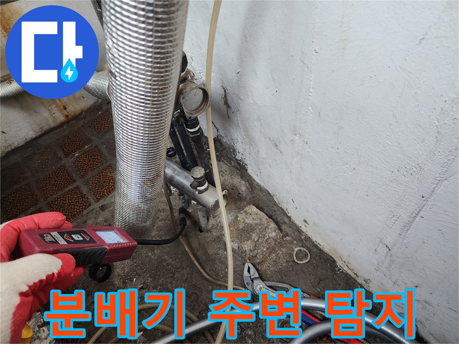 금속 재질의 배관과 가스 탐지 기구가 맞닿아 있는 작업 모습