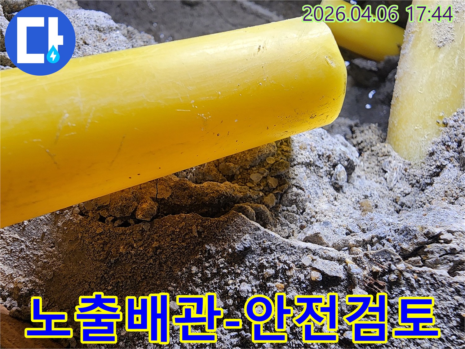누수 공사 중-땅속에서 발견된-노란색 배관의-안전 상태를 점검하는-작업 현장의 모습입니다