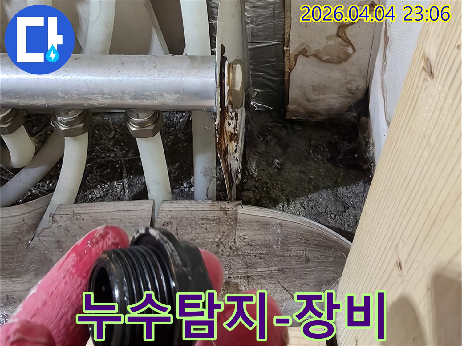 누수-전문가가-첨단-누수-탐지-장비를-활용하여-배관-분배기-주변을-점검하는-모습
