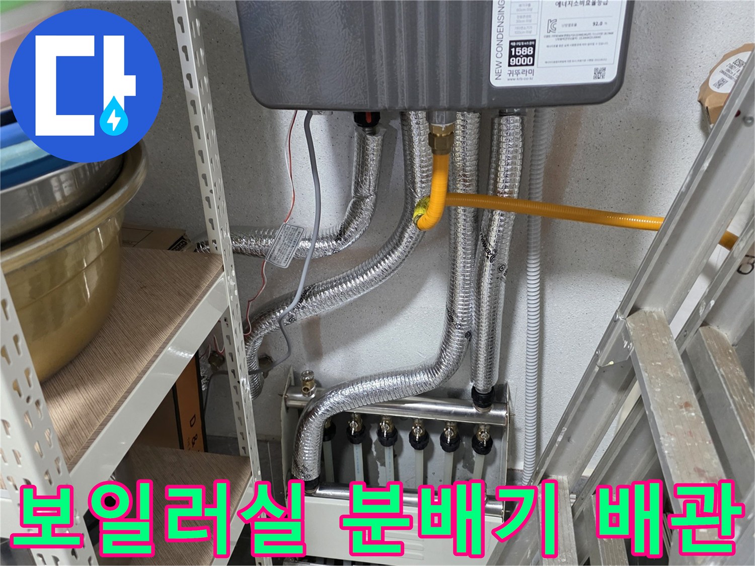 보일러 하단에 연결된 은색 보온재 배관과 분배기 모습