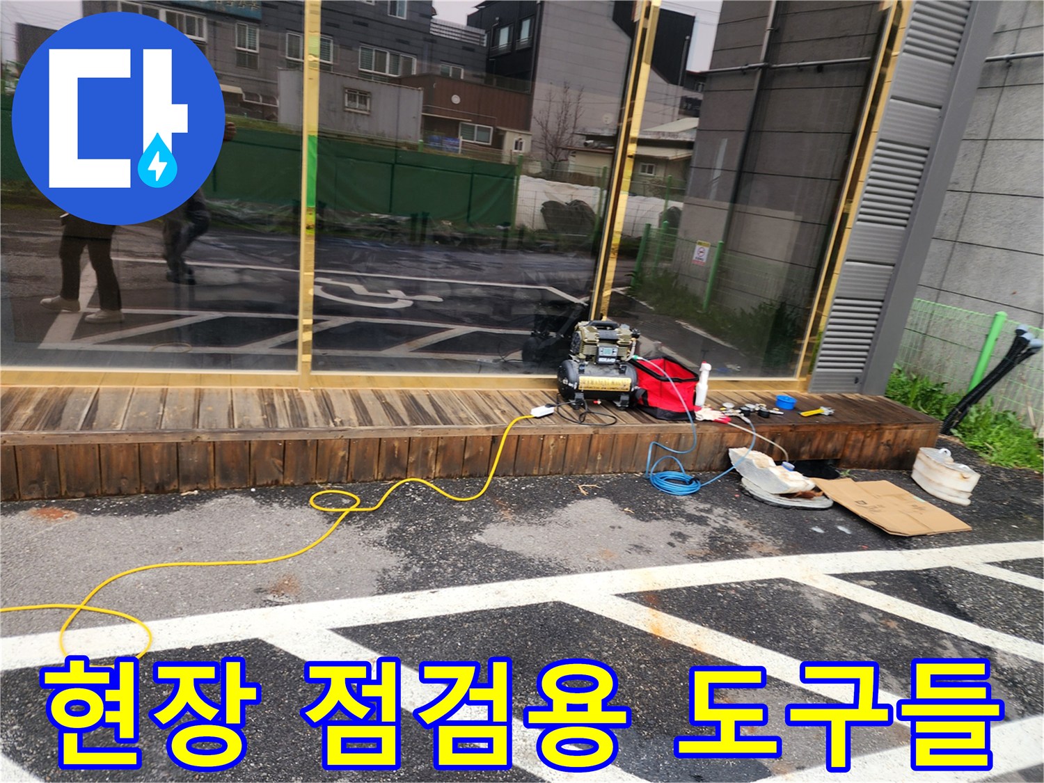 주차장 아스팔트 위에 배치된 누수 탐지 전동 기기와 케이블