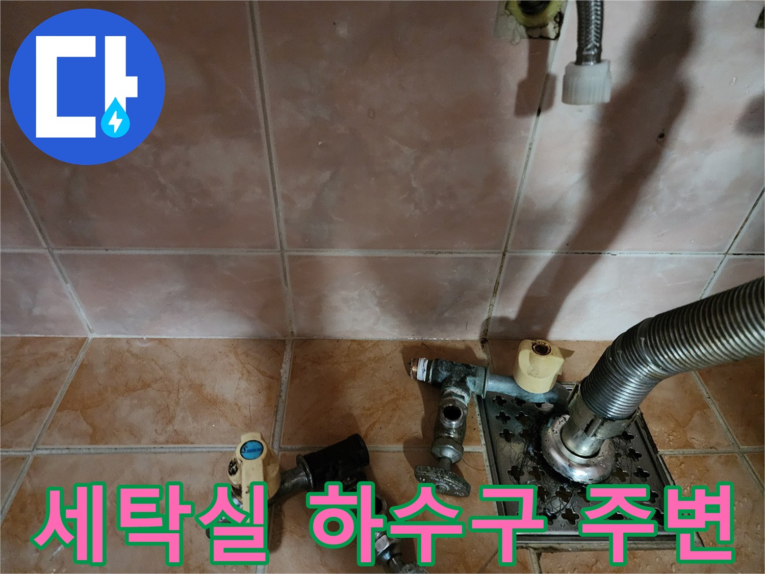 베란다 바닥 배수구와 세탁기 연결 호스의 근접 촬영 사진