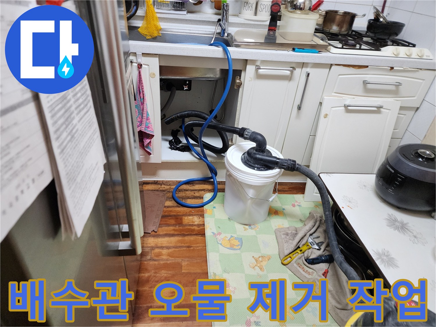 싱크대 아래쪽 배관에 연결된 석션 호스와 수거통의 모습