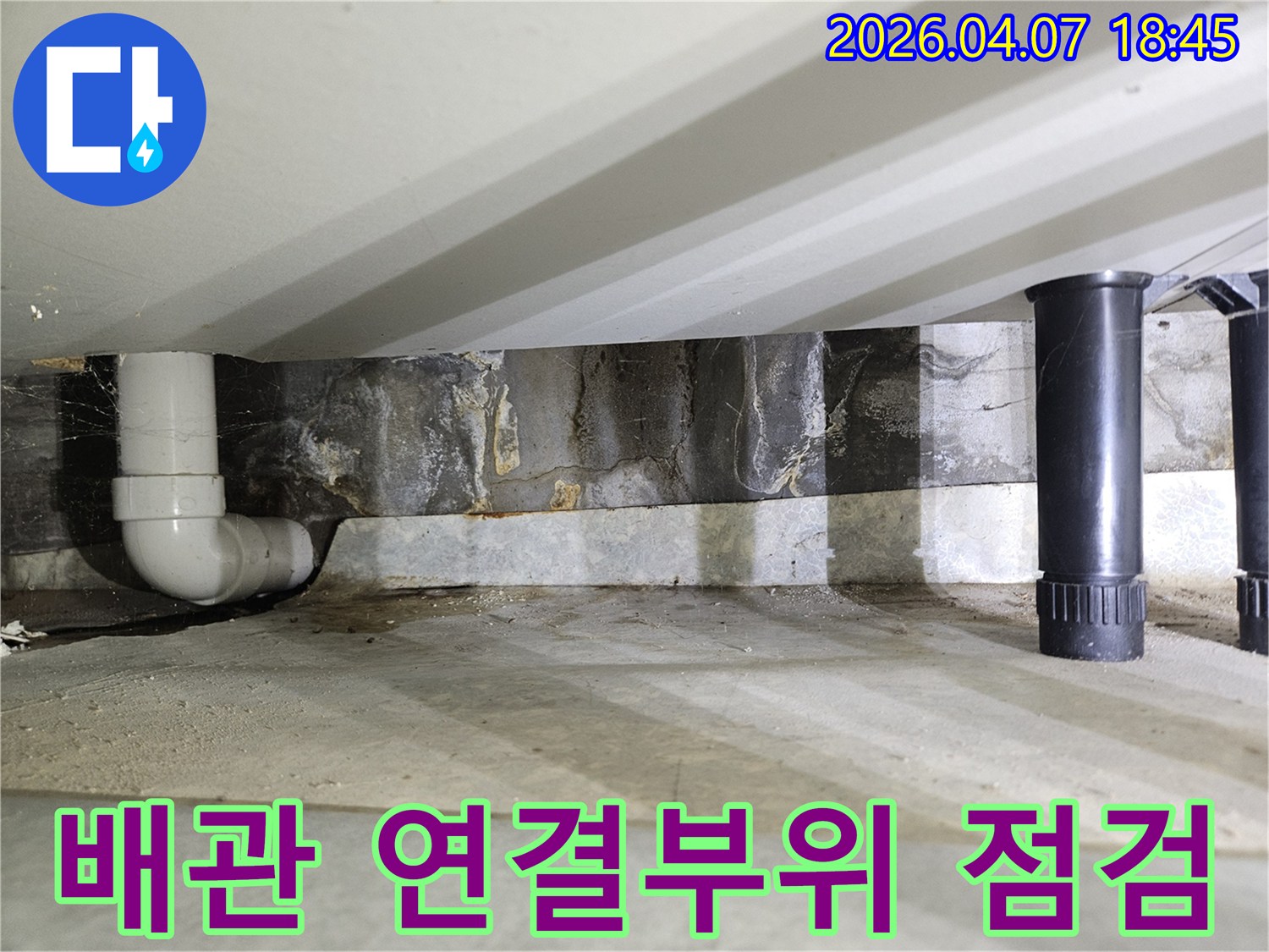 천장 콘크리트 아래-배관의 연결 부위에서-발견된 누수 흔적을-면밀히 보여주는 이미지입니다