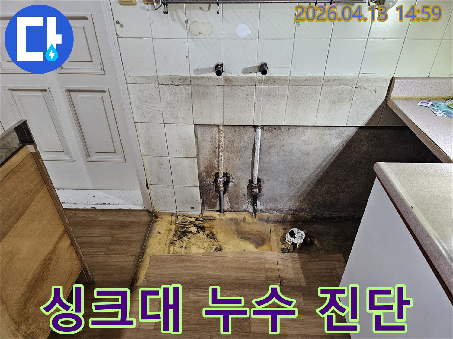 누수 탐지팀이-주방 벽면 타일 아래에서-발견된-오래된 배관의-부식 상태와-누수 지점을-고객에게 명확히-설명하기 위해-촬영한 사진입니다