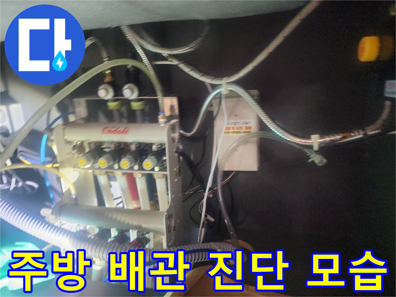 싱크대 아래 분배기에 연결된 다양한 배관들과 탐지 장비들