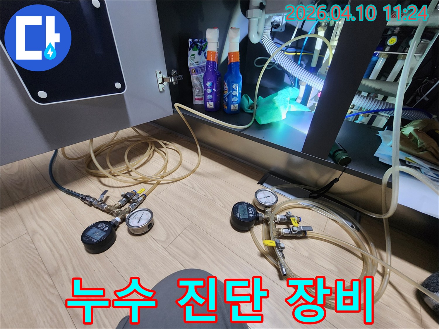 아파트 누수 진단을 위해 사용되는 압력 게이지와 호스 등 전문 장비가 설치된 현장
