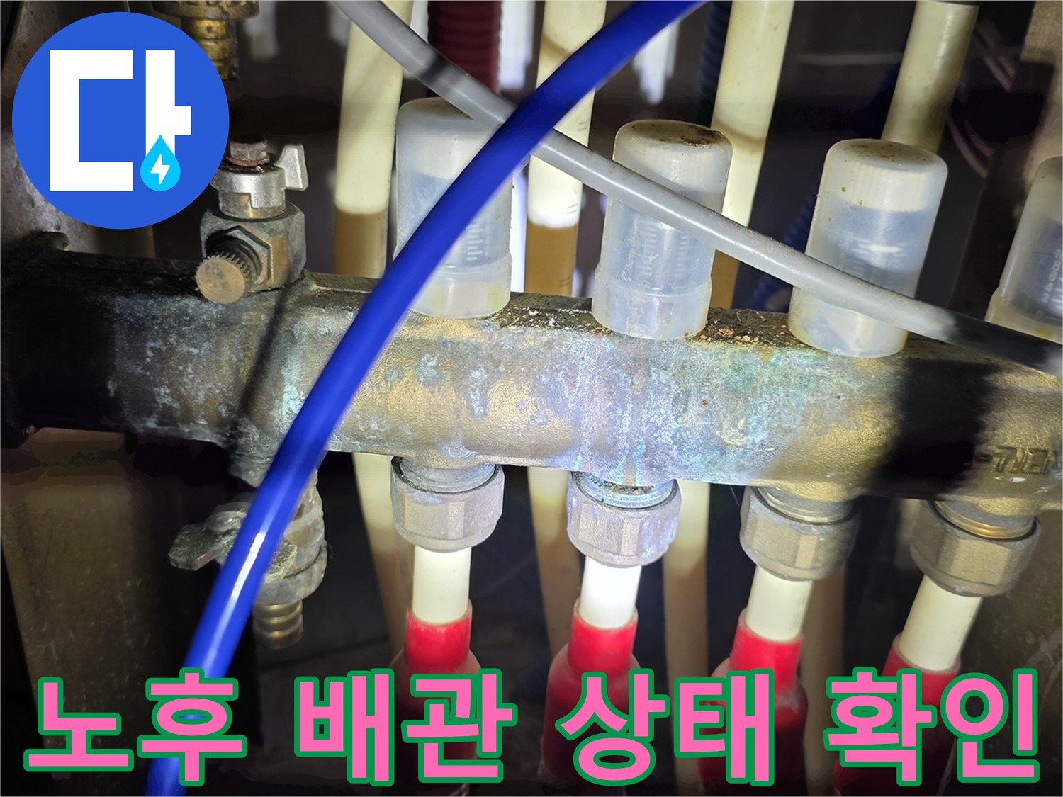 금속 배관의 부식과 연결 부위의 누수 흔적을 근로자가 검사 중