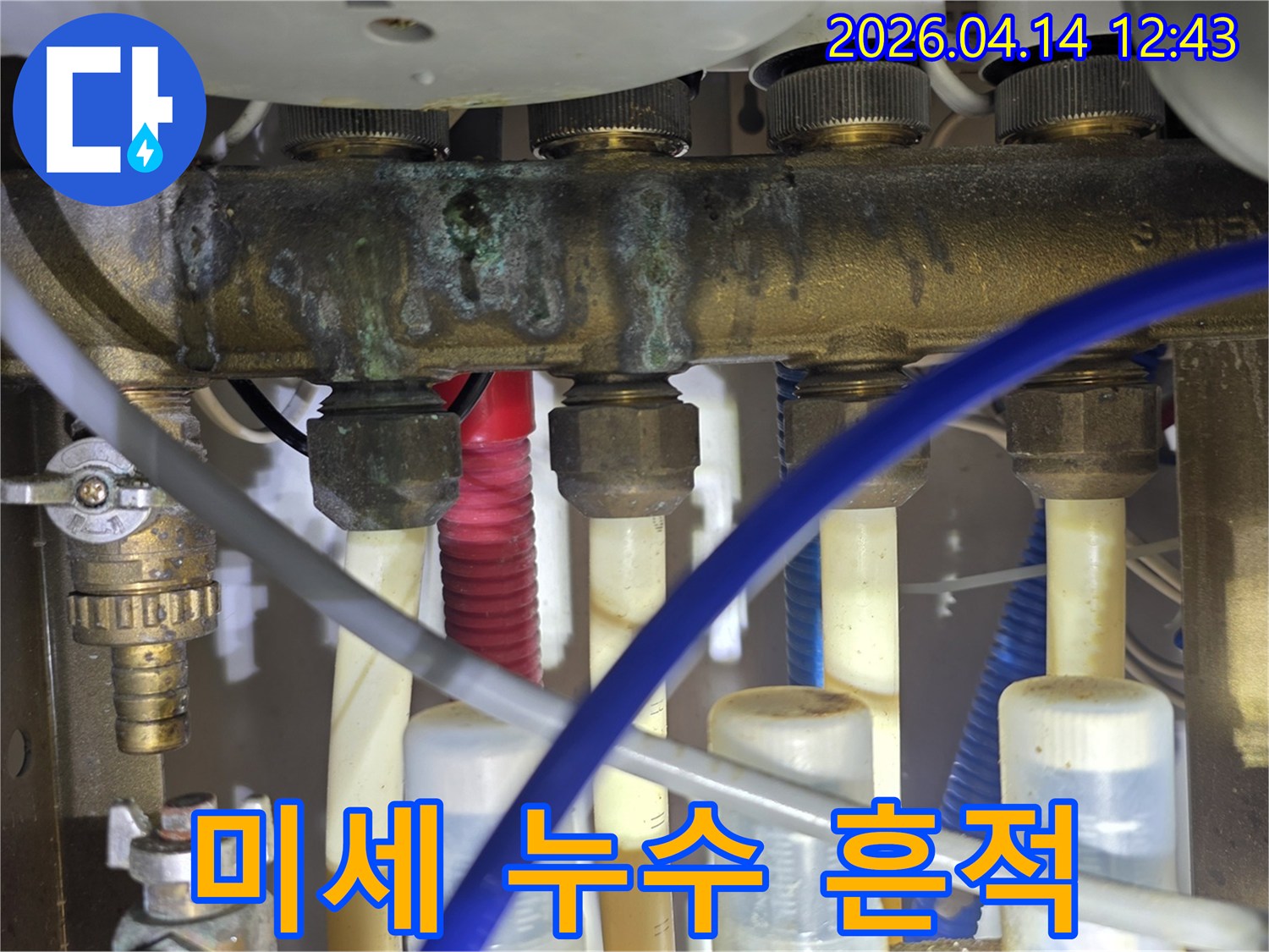 난방 분배기 주변에서 발견된 미세한 누수 흔적과-배관 부식 상태를 보여주는 근접 촬영 이미지