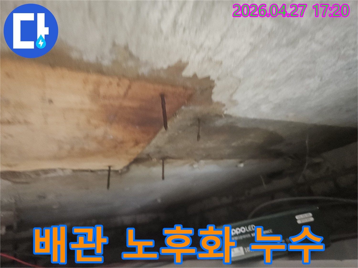 천장 마감재가 젖어-나무판이 떨어져 나가고-녹슨 못이 드러난 배관 누수 현장입니다.
