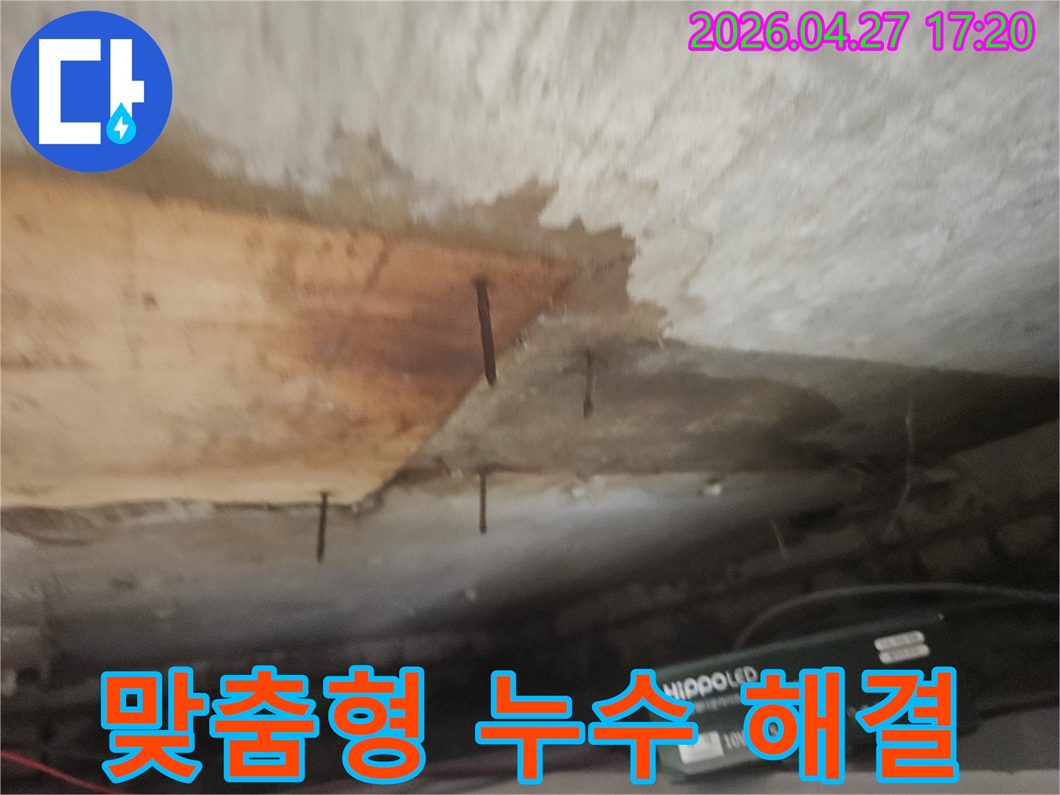 천장 마감재가 젖어-나무판이 떨어져 나가고-녹슨 못이 드러난 배관 누수 현장입니다.