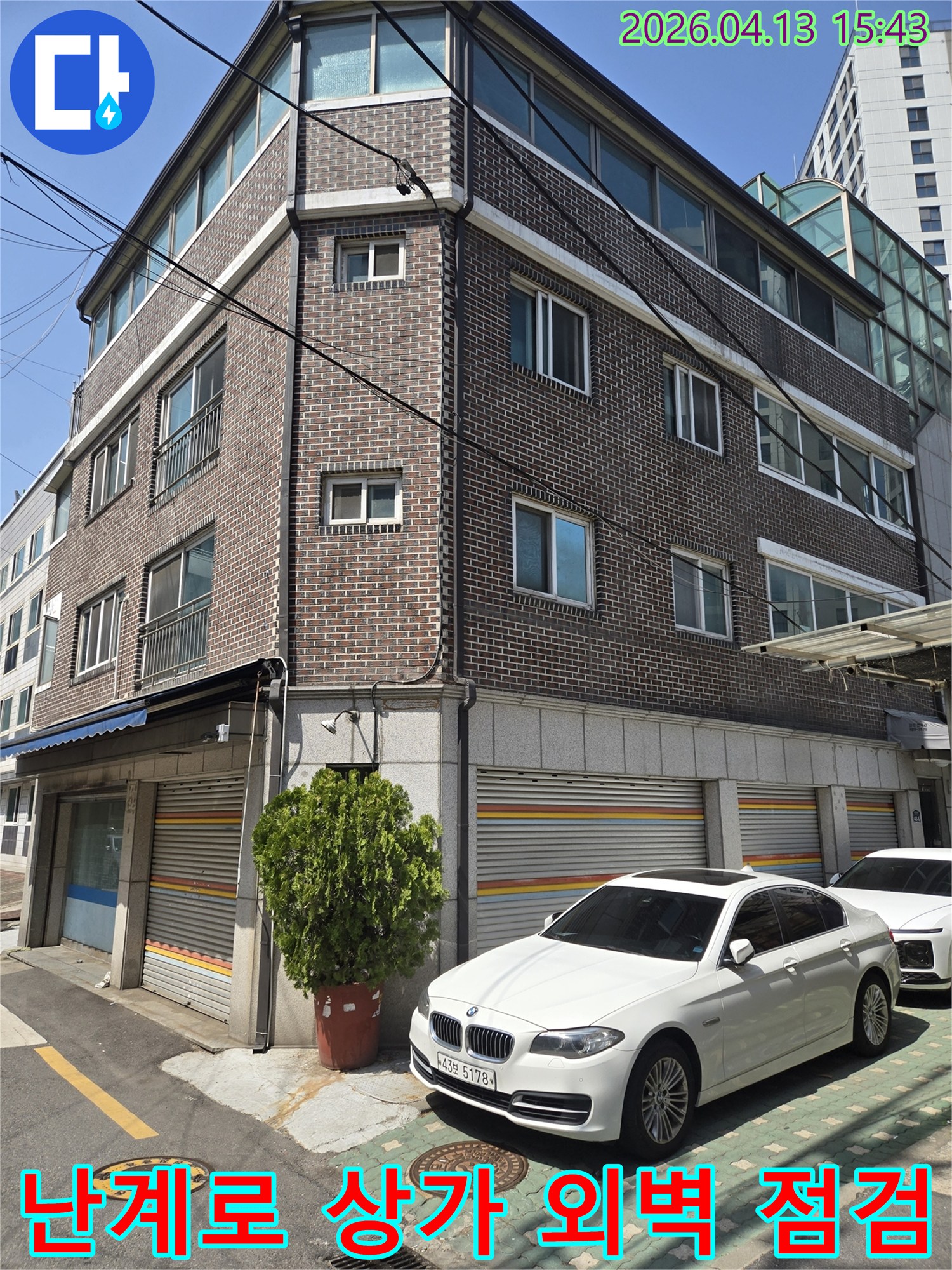 이 이미지는-난계로에 위치한-상가 건물의-외벽 모습을-담고 있으며-누수 문제 해결을 위한-초기 현장-조사 단계를-보여줍니다