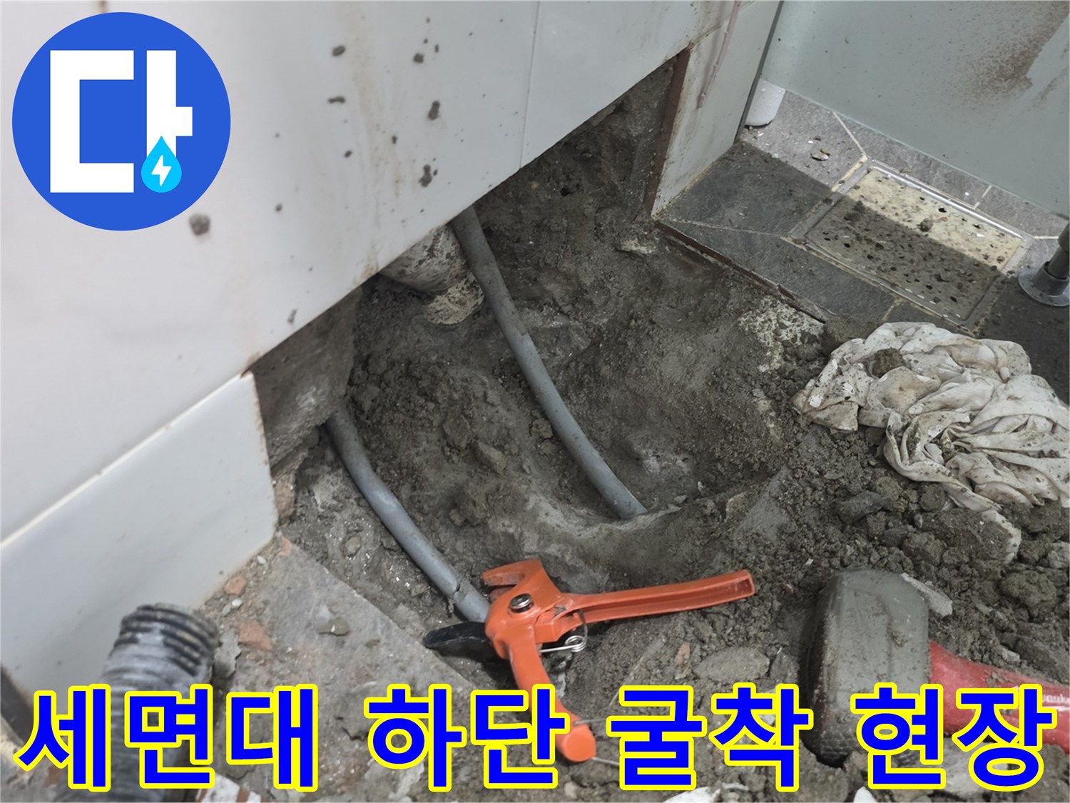욕실 타일 제거 후 드러난 매립된 배관과 공구들이 놓인 작업 현장