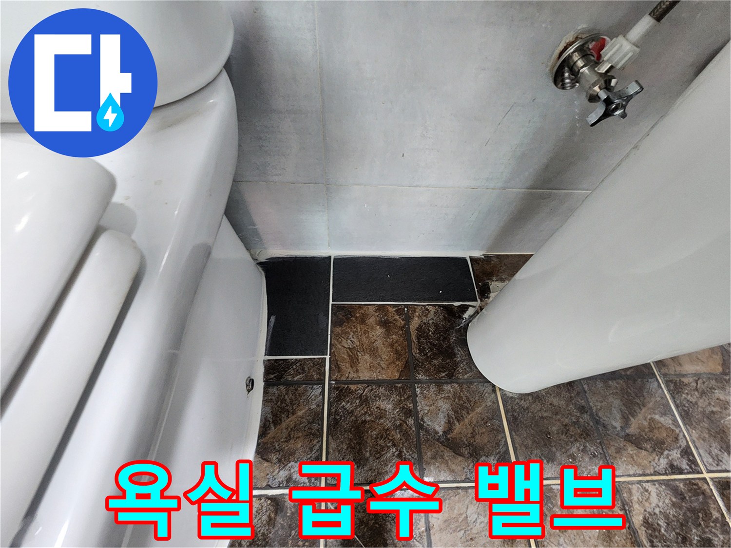 변기 뒤쪽 벽면에 설치된 은색 수전과 연결 호스 근접 촬영