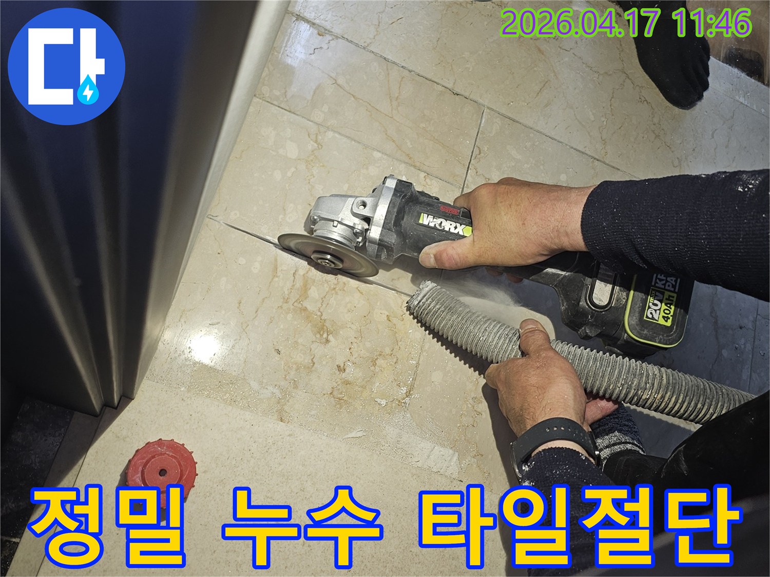 정밀 누수 탐지 및 보수를 위해 작업자가 그라인더로 바닥 타일을 절단하고-있으며-동시에-흡진기로-먼지를-제거하여-깨끗한-작업-환경을-유지하는-모습입니다.