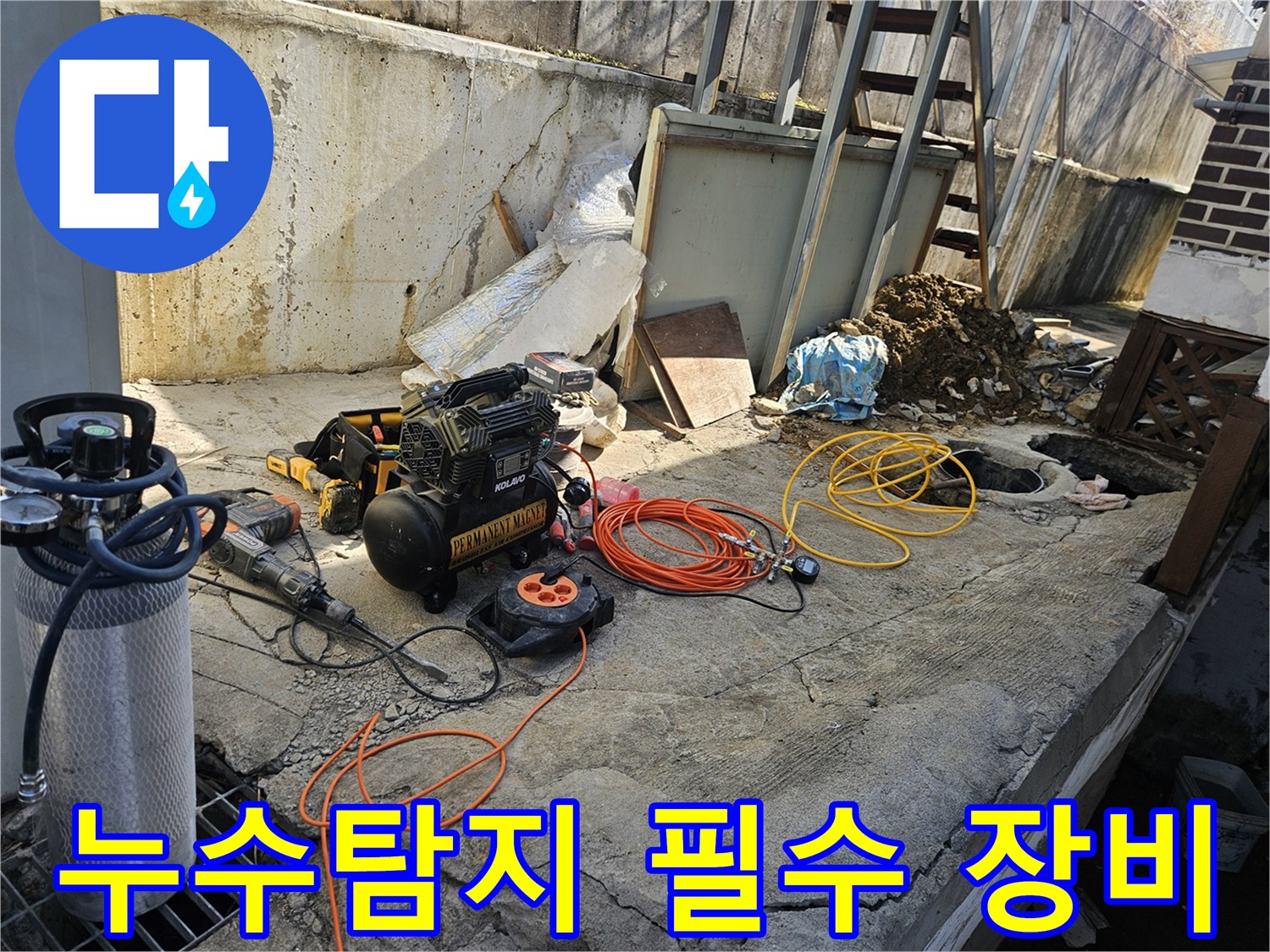누수 공사 현장에서-에어 콤프레셔-함마드릴-호스-전선릴 등-다양한 전문 장비들이-콘크리트 바닥 위에-정돈된 채-작업 준비를 마친 모습
