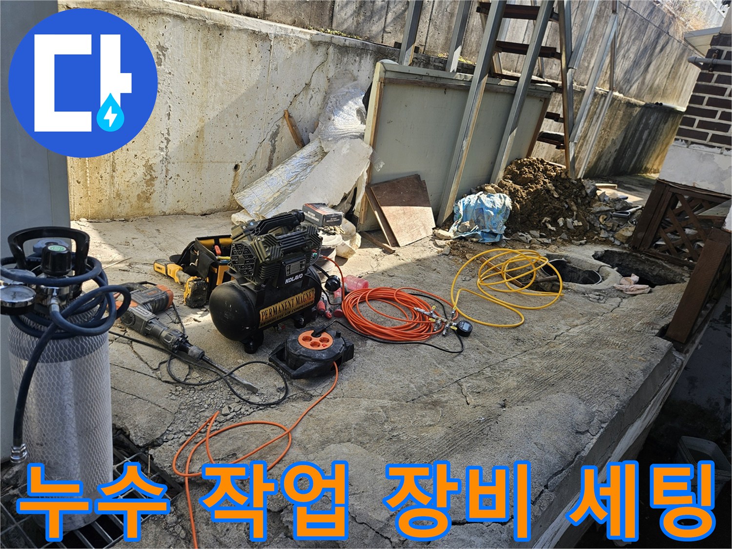 누수 공사를 위해-에어 콤프레셔-함마드릴-각종 호스 및 전선릴 등-필수 장비들이-콘크리트 바닥 위에-정돈된 채-작업 준비를 마친 모습