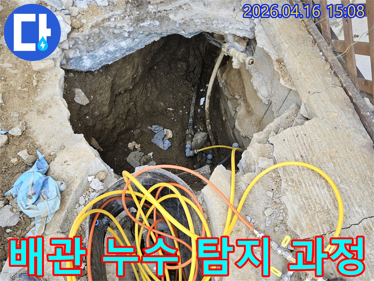 땅속에 매설된 배관에서 누수 지점을 찾아내기 위해-땅을 파내고 전문 압력 테스트 장비를 연결하여-정밀하게 진단하는 작업 현장입니다.
