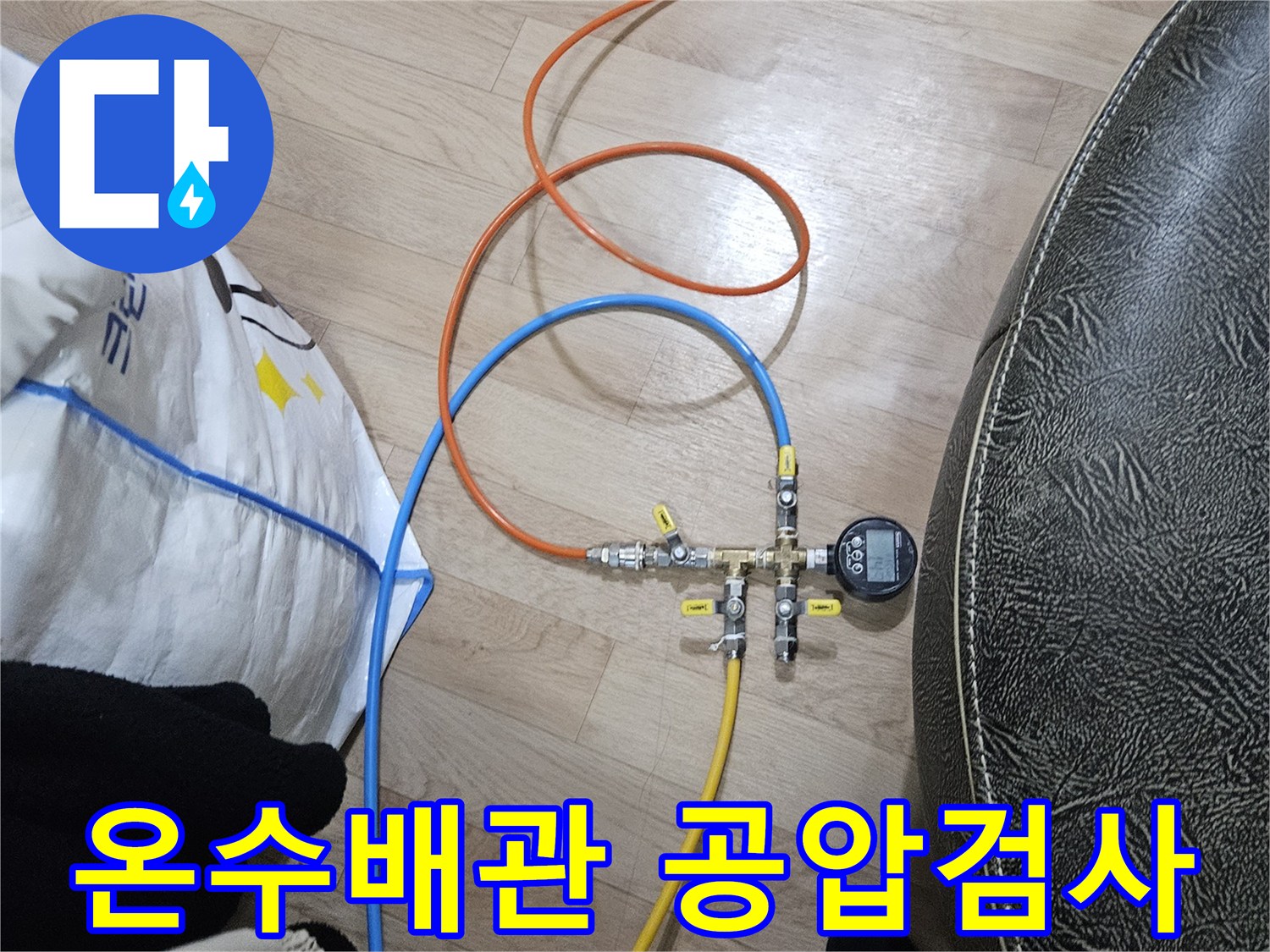 누수 엔지니어가 온수 배관의 누수 여부를 확인하기 위해-공압 검사 장비를 연결하여 압력을 측정하고 있습니다