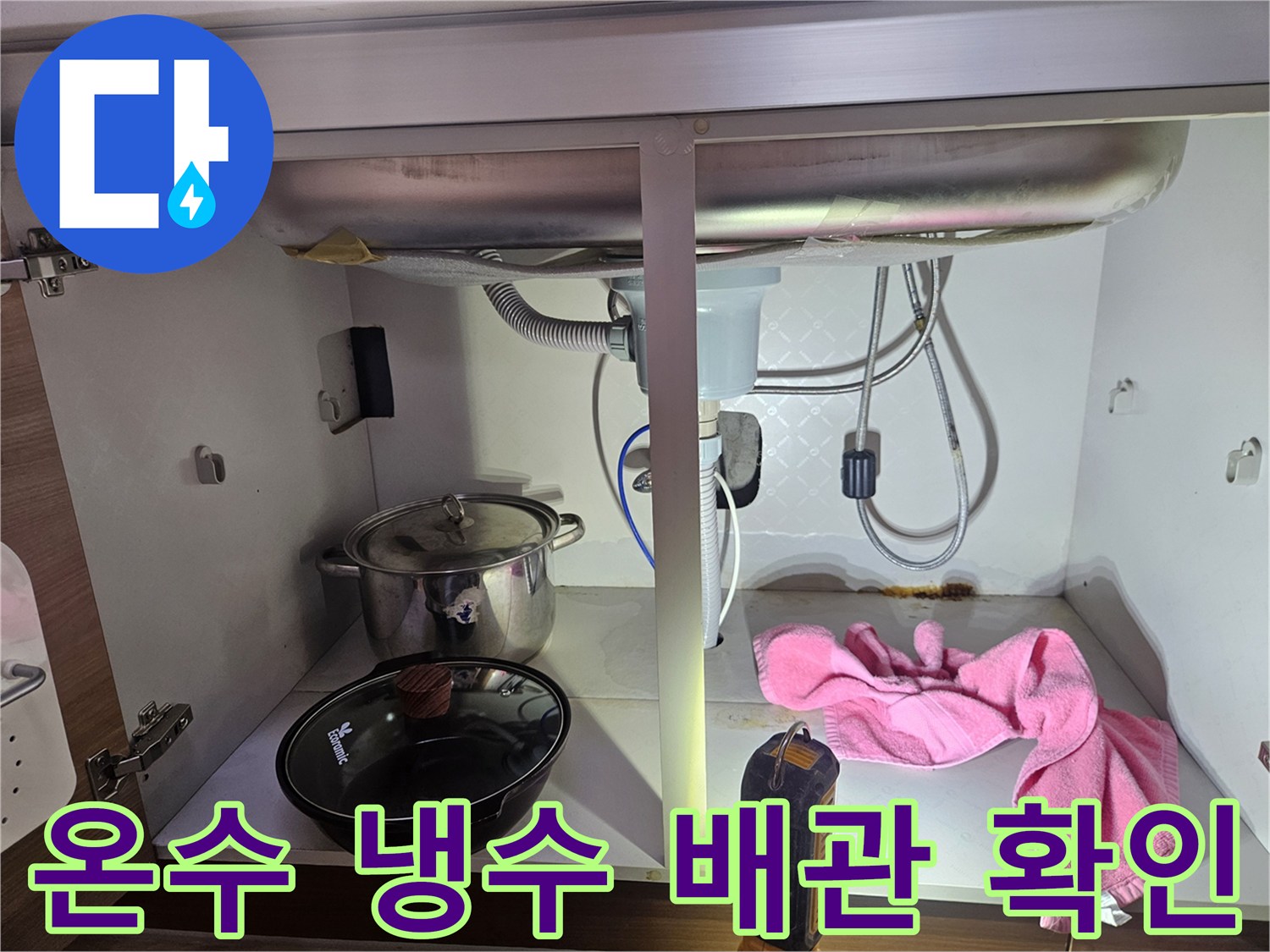 싱크대-하부의-온수-및-냉수-배관에서-누수-여부를-확인하는-전문가의-작업-모습을-보여주는-사진입니다