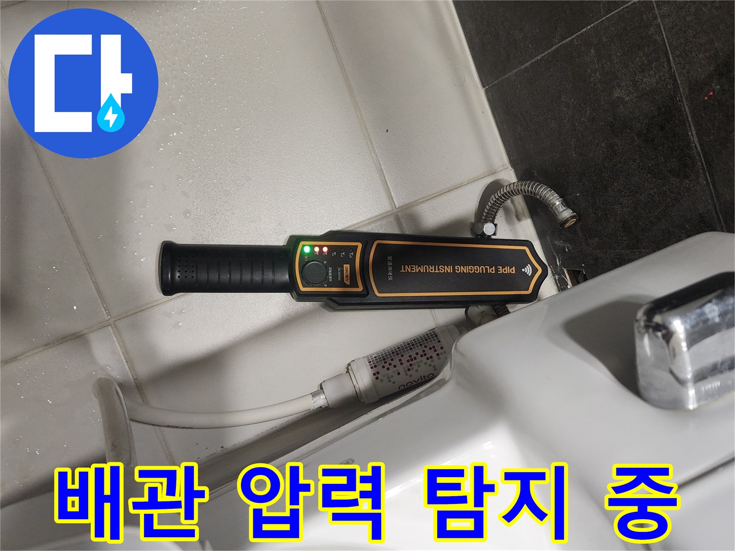 변기 뒤쪽 배관의 미세 누수를 감지하기 위해 장비를 운용하는 장면입니다.