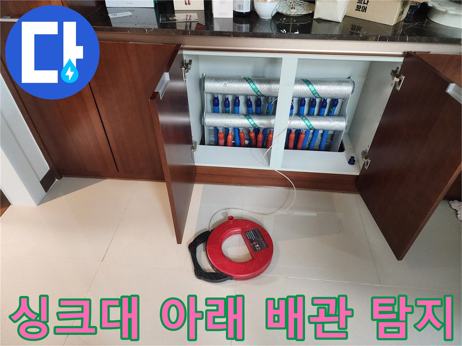 하부장-내부의-배관-연결부와-빨간색-측정-도구
