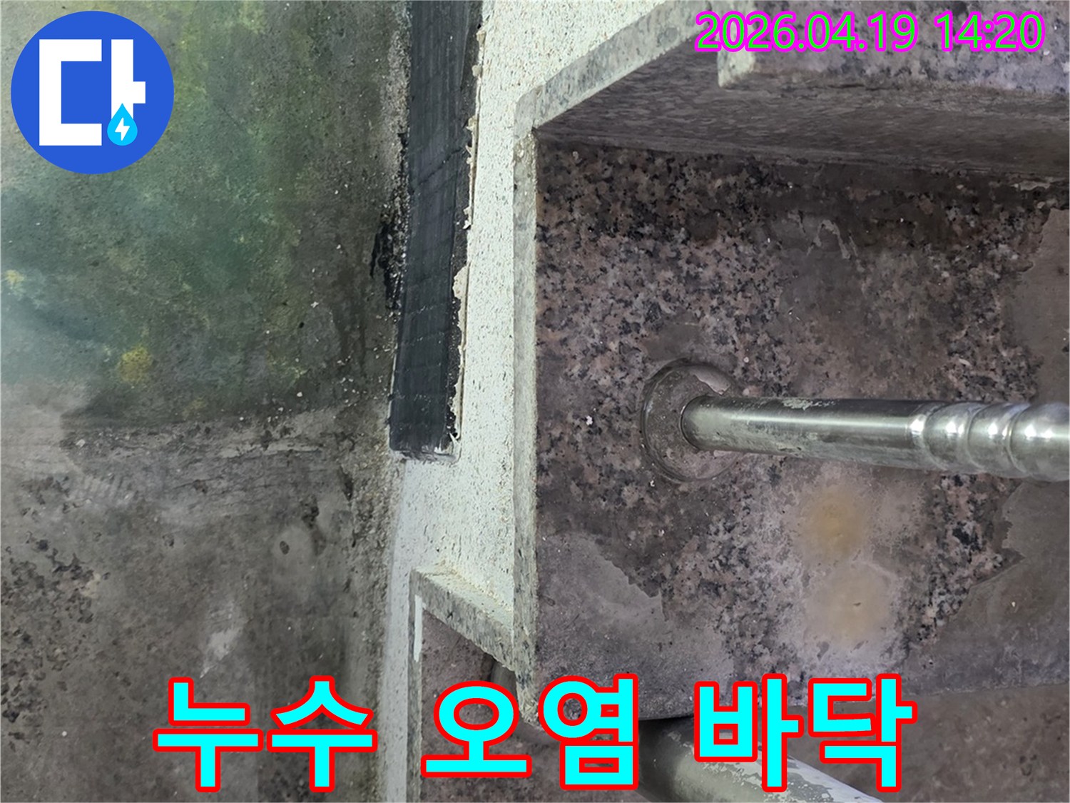 난간 기둥 하단부와-계단 바닥 경계면에 발생한-지속적인 물기로 인한-오염과 부식의 증거