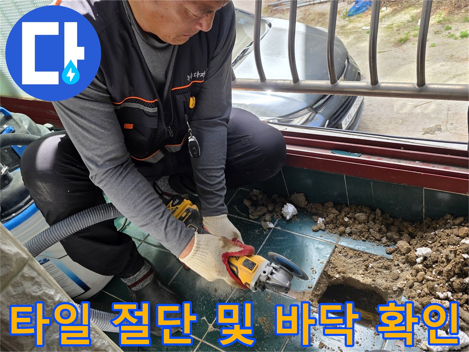 전동 공구를 사용하여 누수 부위 주변 타일을 제거하는 장면