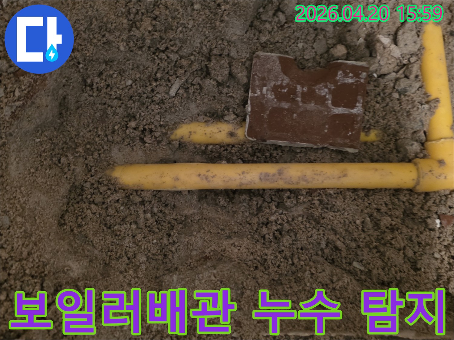 흙 속에 매설된 노란색 보일러 배관에서-누수 지점을 정밀하게 탐지하는 현장입니다