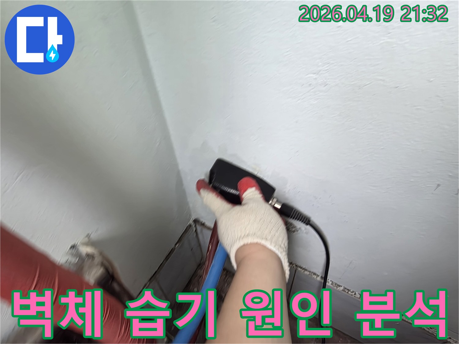 누수 전문 엔지니어가 벽체에 대고 습도 측정 장비로 누수 원인을 정밀하게 분석하는 장면
