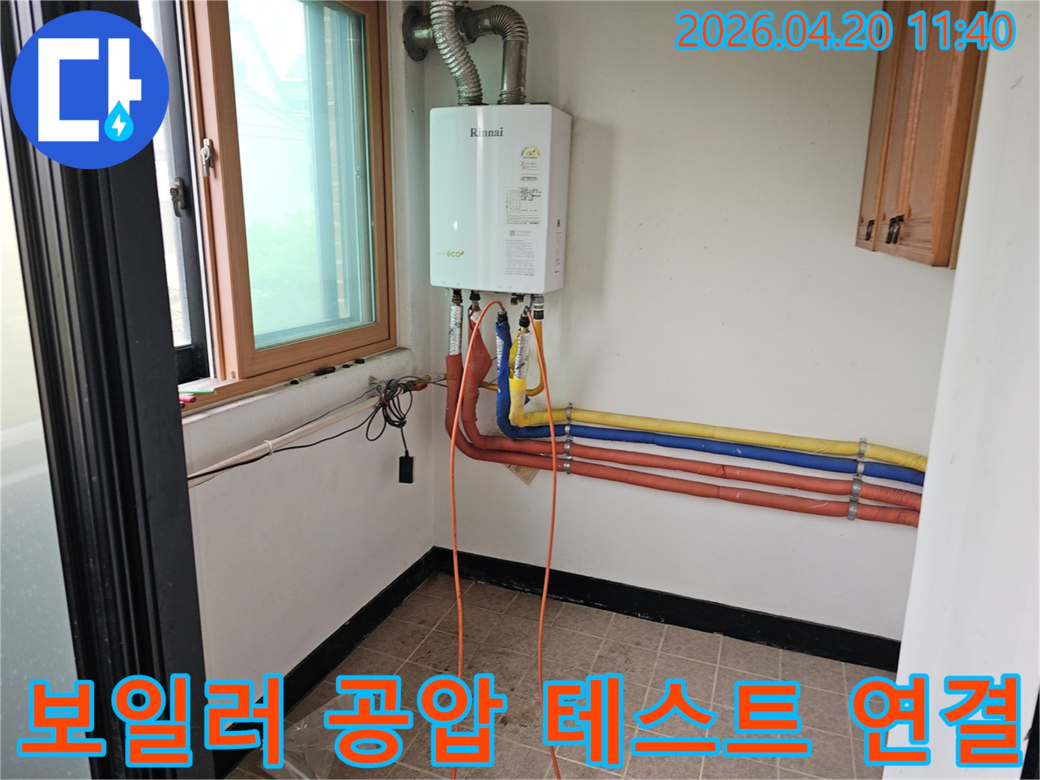 누수 탐지를 위해 보일러에 공압 테스트 장비를 연결하는 모습