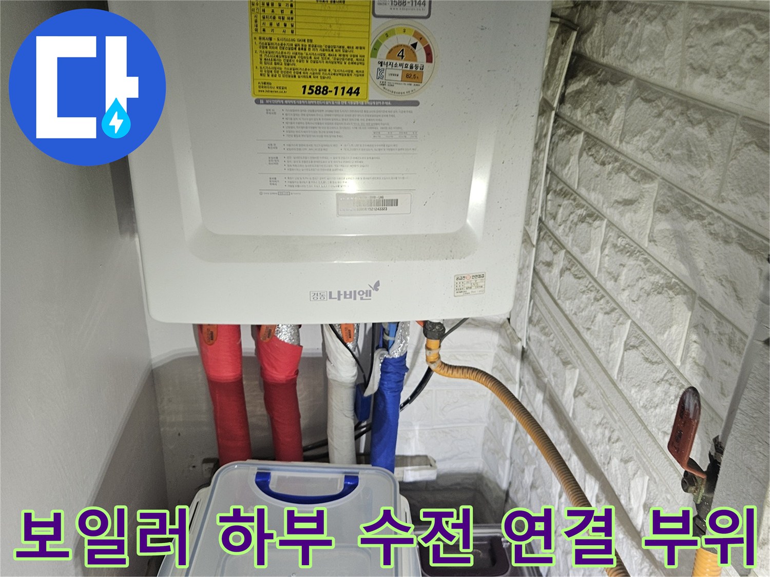 보일러 아래쪽으로 뻗어 나온 급수 및 온수 배관의 연결 상태를 보여줍니다.