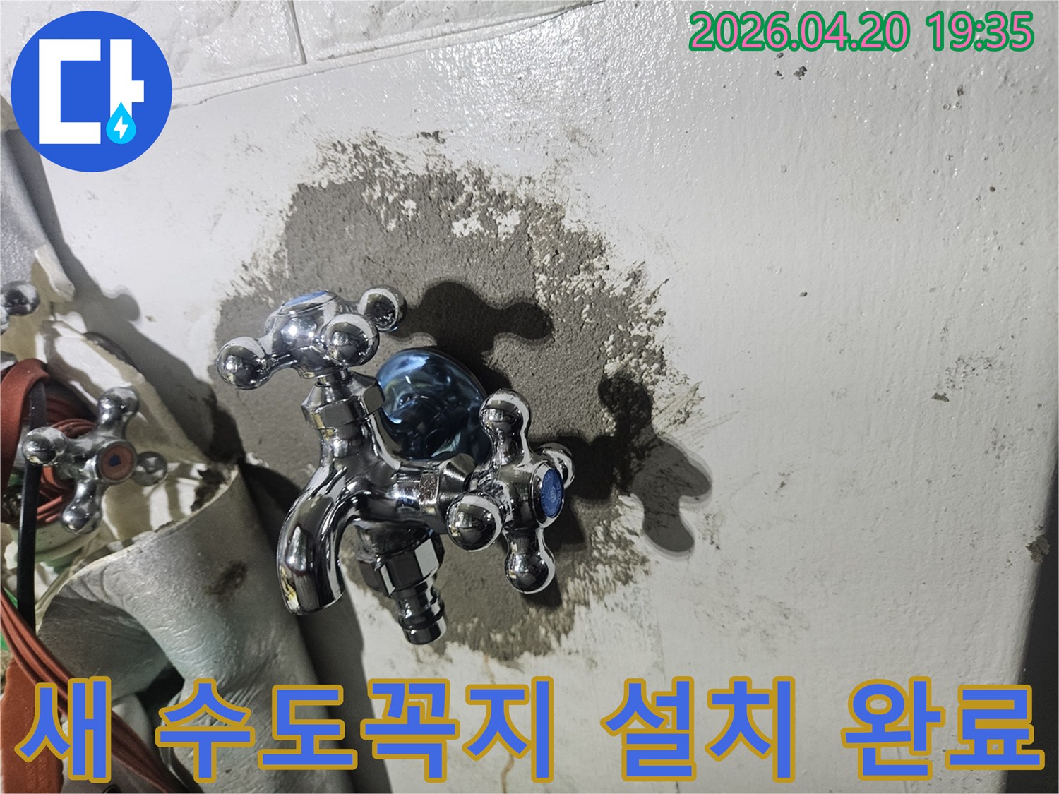 새로 설치된 반짝이는 수도꼭지가 회색 시멘트로 마감된 벽면에 단단히 고정되어 누수 문제를 해결한 모습을 보여줍니다.
