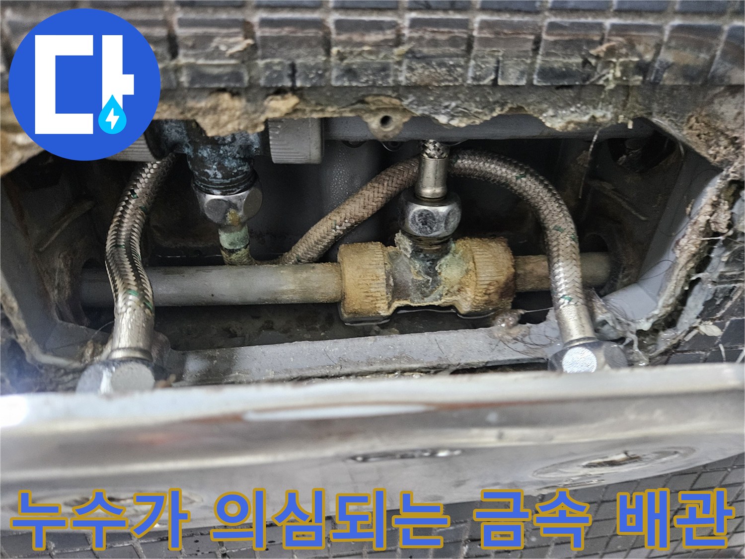물기가 묻어 있고 변색된 싱크대 아래쪽 배관 연결부